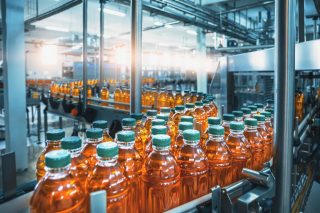 Conveyor belt, juice in bottles, beverage factory interior in blue color, industrial production line.; Shutterstock ID 1709414143; purchase_order: Life Sciences (LS)- AMER; job: Webinar Imagery; client: Sara Engesath-LS-NORAM; other: 