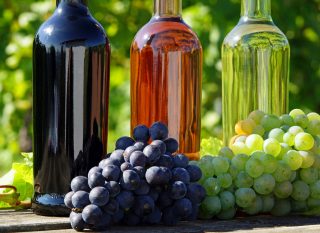 Stock Photography: Fotolia_44977462_X.jpg Wine Bottles Grapes Outdoors on Table